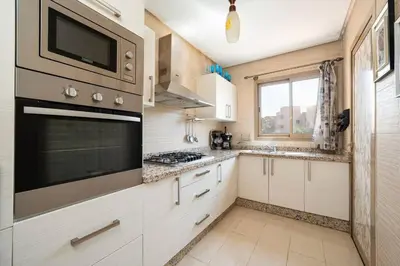 a kitchen with white cabinets and a stove top oven at Relax front of Golf-Pool-Topaze in Marrakech