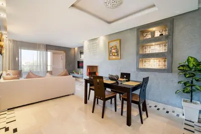 a living room with a dining table and a couch at Relax front of Golf-Pool-Topaze in Marrakech