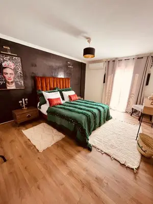 a bedroom with a bed with a green blanket at Loft Gueliz in Marrakech