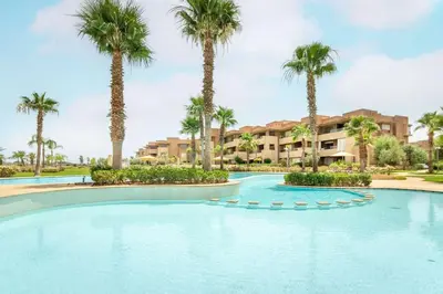 a swimming pool with palm trees in a resort at PO 10 Appartement de luxe, golf, piscine & club house in Marrakech