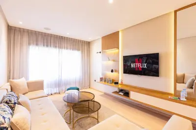 a living room with a white couch and a tv at PO 10 Appartement de luxe, golf, piscine & club house in Marrakech