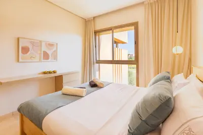 a bedroom with a large bed and a window at PO 10 Appartement de luxe, golf, piscine & club house in Marrakech