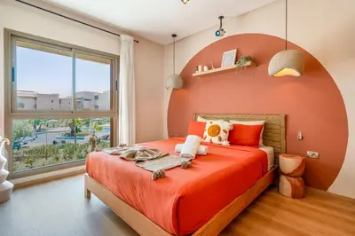 a bedroom with an orange bed with a large window at Chic Escape Sunny Terrace Pool Cenima Bed Fiber Wi-Fi in Marrakech