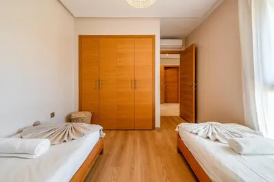 two beds in a room with a closet at Chic Escape Sunny Terrace Pool Cenima Bed Fiber Wi-Fi in Marrakech