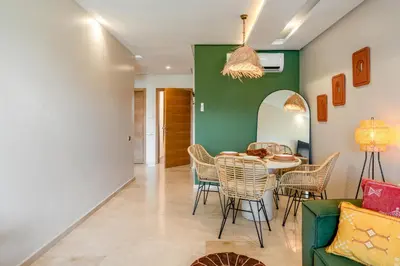a dining room with a table and chairs and a green wall at Chic Escape Sunny Terrace Pool Cenima Bed Fiber Wi-Fi in Marrakech