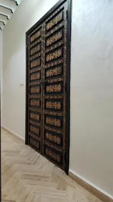 a wall with a wooden door in a room at Riad marrakech boujloud in Marrakech