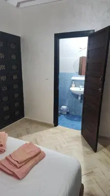 a bedroom with a bed and a door to a bathroom at Riad marrakech boujloud in Marrakech