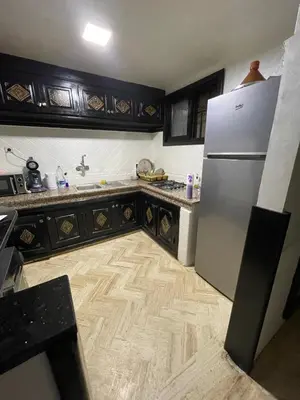 a kitchen with a refrigerator and a wooden floor at Riad marrakech boujloud in Marrakech