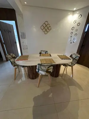 a wooden table and chairs in a room at Appartement pour famille ou couple à Marrakech in Marrakech