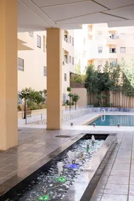 a swimming pool in the middle of a building at Appartement pour famille ou couple à Marrakech in Marrakech