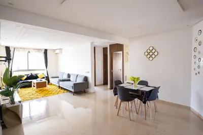 a living room with a table and a couch at Appartement pour famille ou couple à Marrakech in Marrakech