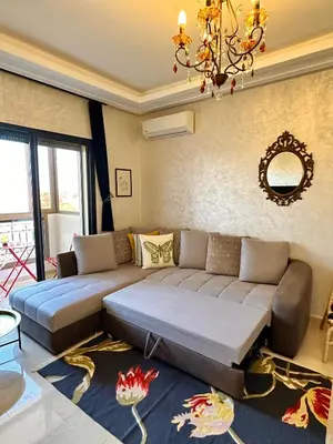 a living room with a couch and a chandelier at Appartement Zazat in Marrakech