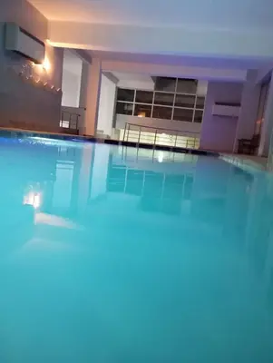 a large swimming pool with chairs in a building at Gueliz Luxury Apt with Pool Self Check In 24 7 Security in Marrakech