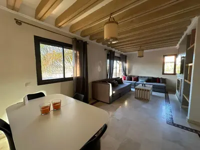 a living room with a table and a couch at Résidence Dar Damana Palmeraie Marrakech in Marrakech