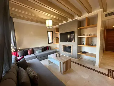 a living room with a couch and a fireplace at Résidence Dar Damana Palmeraie Marrakech in Marrakech