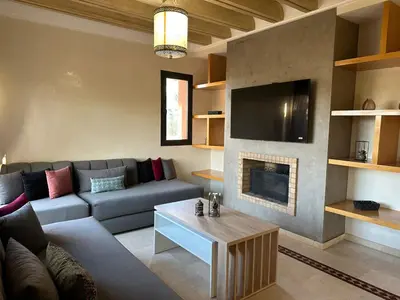 a living room with a couch and a fireplace at Résidence Dar Damana Palmeraie Marrakech in Marrakech