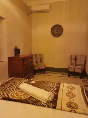 a bedroom with a bed and two chairs and a dresser at Medina Oasis Hostel in Marrakech