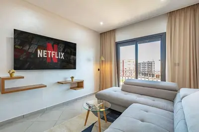a living room with a couch and a large window at R35 Paisible et tout confort : Netflix+parking+Wifi gratuit in Marrakech