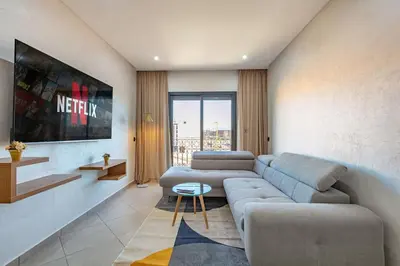 a living room with a couch and a table at R35 Paisible et tout confort : Netflix+parking+Wifi gratuit in Marrakech