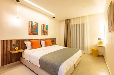 a bedroom with a large bed with orange pillows at R35 Paisible et tout confort : Netflix+parking+Wifi gratuit in Marrakech