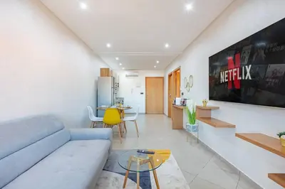 a living room with a couch and a table at R35 Paisible et tout confort : Netflix+parking+Wifi gratuit in Marrakech