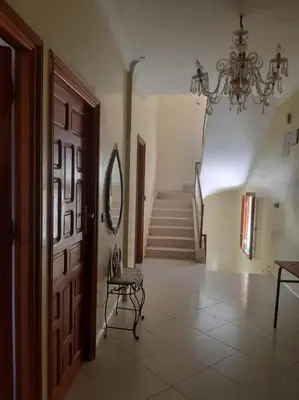 a hallway with a door and a chair and stairs at Calm Cosy Villa in Marrakech