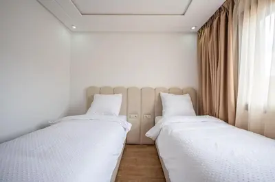 two beds sitting next to each other in a bedroom at appartement 3 chambres avec piscine in Marrakech