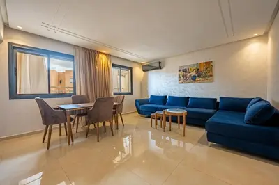 a living room with a blue couch and a table at appartement 3 chambres avec piscine in Marrakech