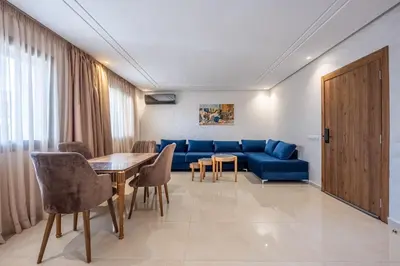 a living room with a blue couch and a table at appartement 3 chambres avec piscine in Marrakech