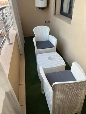 two white wicker chairs and a table on a balcony at appartement 3 chambres avec piscine in Marrakech