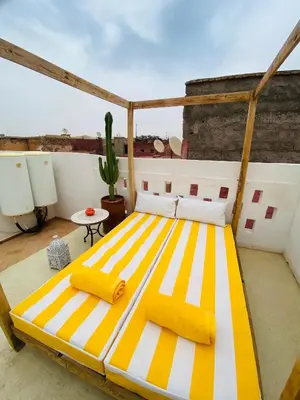 a large yellow and white bed on a balcony at Riad Fiora, private home!!! in Marrakech