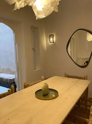 a dining room table with a mirror and a wooden table at Riad Fiora, private home!!! in Marrakech