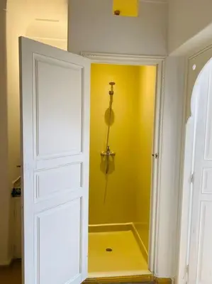 a bathroom with a shower with a yellow wall at Riad Fiora, private home!!! in Marrakech