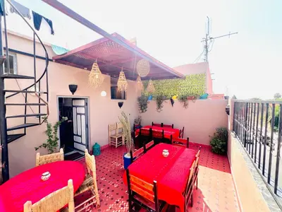 a patio with red tables and chairs on a balcony at Al Bahja family in Marrakech