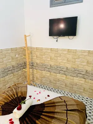 a room with a bed with a tv on a wall at Al Bahja family in Marrakech