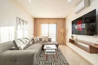 a living room with a couch and a table at RA26 Elegant&Chaleureux Netflix et parking gratuit in Marrakech
