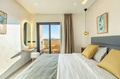 a bedroom with a large bed and a balcony at RA26 Elegant&Chaleureux Netflix et parking gratuit in Marrakech