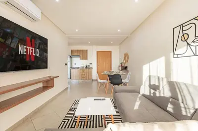 a living room with a couch and a table at RA26 Elegant&Chaleureux Netflix et parking gratuit in Marrakech