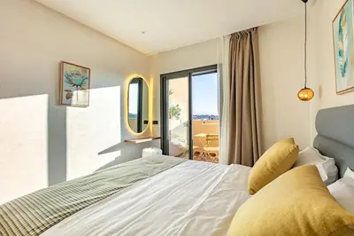 a bedroom with a large white bed and a balcony at RA26 Elegant&Chaleureux Netflix et parking gratuit in Marrakech