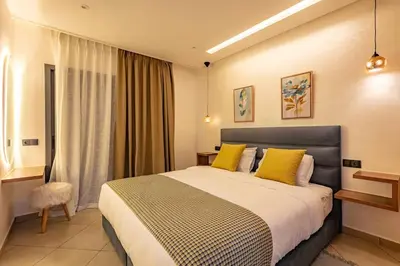 a bedroom with a large bed with yellow pillows at RA26 Elegant&Chaleureux Netflix et parking gratuit in Marrakech