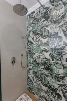 a shower in a bathroom with a leafy shower curtain at Red City Rendezvous – Downtown in Marrakech