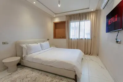 a bedroom with a large bed and a window at Red City Rendezvous – Downtown in Marrakech