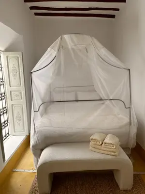 a white bed with two towels sitting on a bench at Little 24 in Marrakech