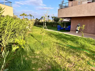 a yard with a green hose in the grass at Golf stay with Atlas view at Marrakech! in Marrakech