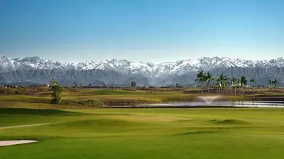 a view of a golf course with mountains in the background at Golf stay with Atlas view at Marrakech! in Marrakech