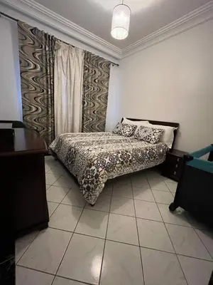 a bedroom with a bed and a table and curtains at Tigami in Marrakech