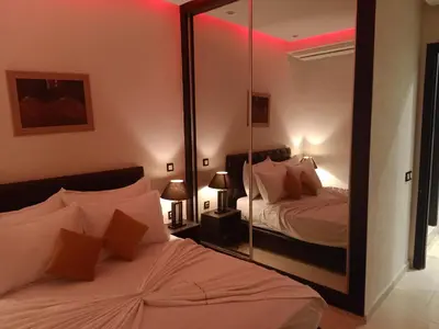 a bedroom with two beds and a mirror at Appartement Bayt Atik in Marrakech
