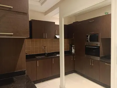 a kitchen with brown cabinets and a microwave at Appartement Bayt Atik in Marrakech