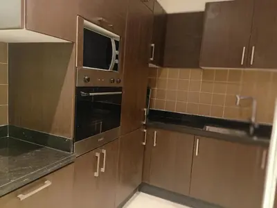 a kitchen with brown cabinets and a microwave at Appartement Bayt Atik in Marrakech