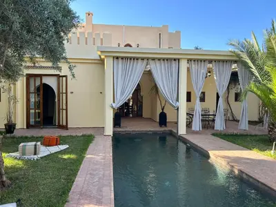 a house with a swimming pool in front of it at Palais Ines in Marrakech